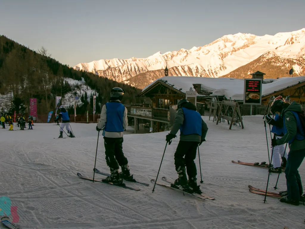 Zwei Skifahrende auf der Piste im Abendlicht.